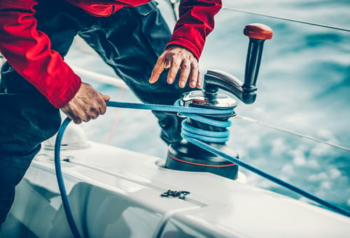 Skipper avec la corde du treuil à la main.